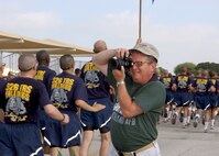 7/11/2009 - Tony Stencel, a freelance artist with the Air Force Art Program, takes photos of trainees during the Airman's Run July 11. The team visited Lackland to learn about the 37th Training Wing so they can produce paintings or drawings to illustrate the wing's missions. (U.S. Air Force photo/Alan Boedeker)