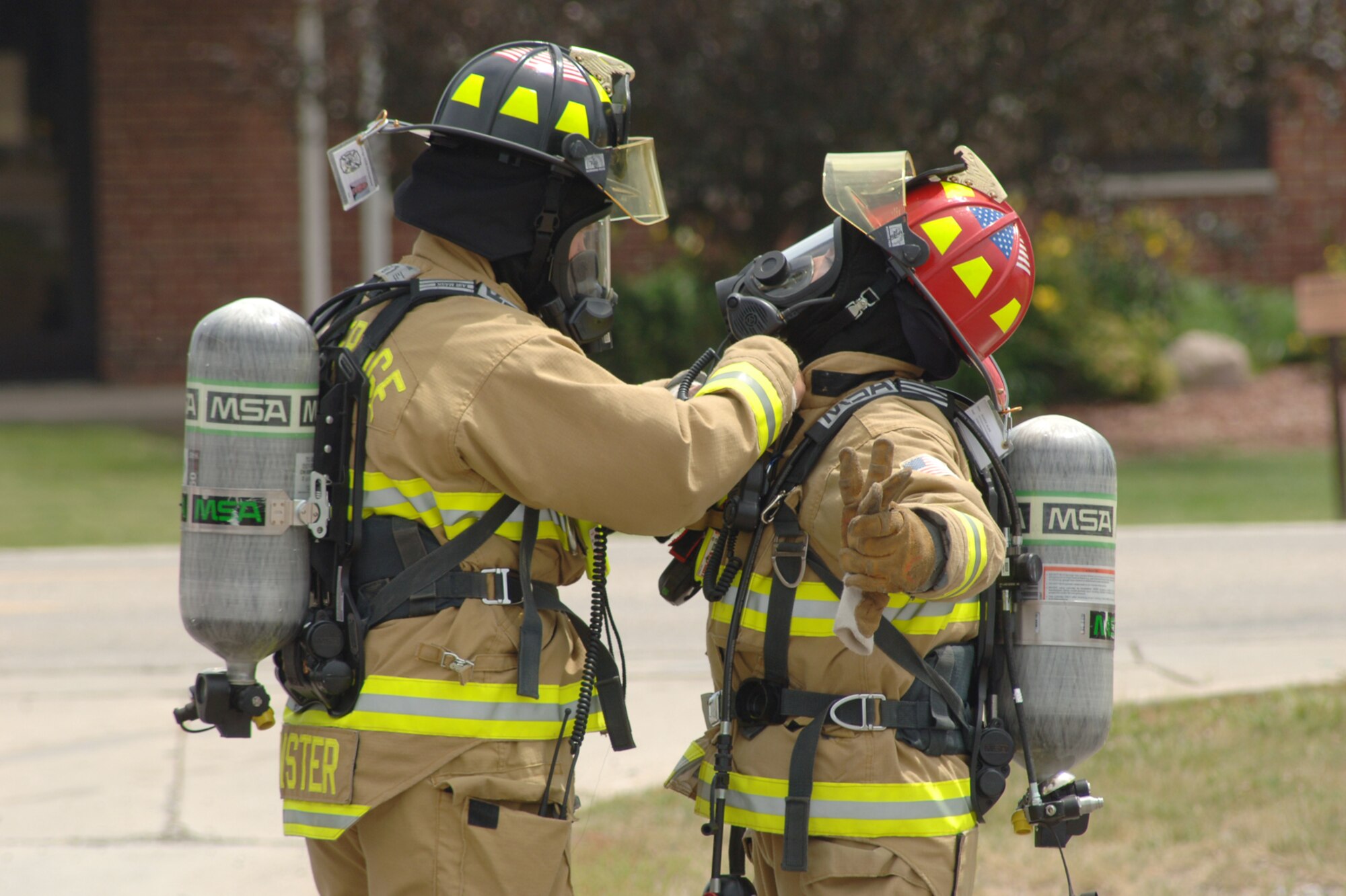 Dustin Brewster (left) of the Selfridge Fire Department checks fellow firefighter Manny Alam’s uniform for exposed skin or air leaks to ensure he is secure to enter a chemically contaminated area. This exercise was simulated to prepare firefighters and other emergency response personnel in the event of a chemical spill. Even before entering an exercise, firefighters are expected to perform these uniform sufficiency checks to ensure they are ready for real-life emergency situations. (USAF Photo by John S. Swanson)