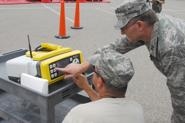 MSgt. Lloyd Miller (left) and Capt. Mark Sitterly of the bioenvironmental engineering team in the 127th Medical Group read data from the HAZID, a specialized piece of equipment that analyzes chemical samples to determine their compositions. For this chemical emergency exercise, Miller and Sitterly determined through this machine that the liquid found in the simulated contaminated area was hydrogen sulfide. (USAF Photo by John S. Swanson)