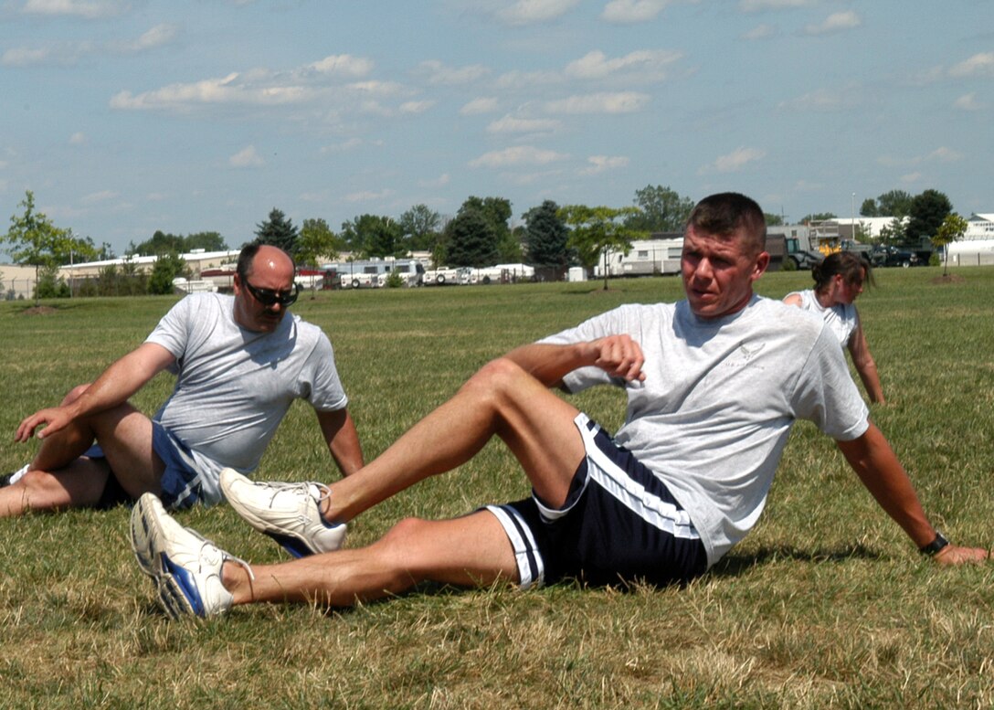 GRISSOM AIR RESERVE BASE, Ind.,-- Master Sgt. Paul Tomlinson, 434th Seasonal Training Flight first sergeant, front,  leads members of the 434th STF in stretches after a mandatory physical training session. The 434th STF program is designed help Airmen get skill level upgrades and for newly assigned Airmen, help them adapt to the base and Air Force life. Along with physical training, members of the flight will perform flag detail and other mission essential details throughout the base. (U.S. Air Force photo/Senior Airman Carl Berry)