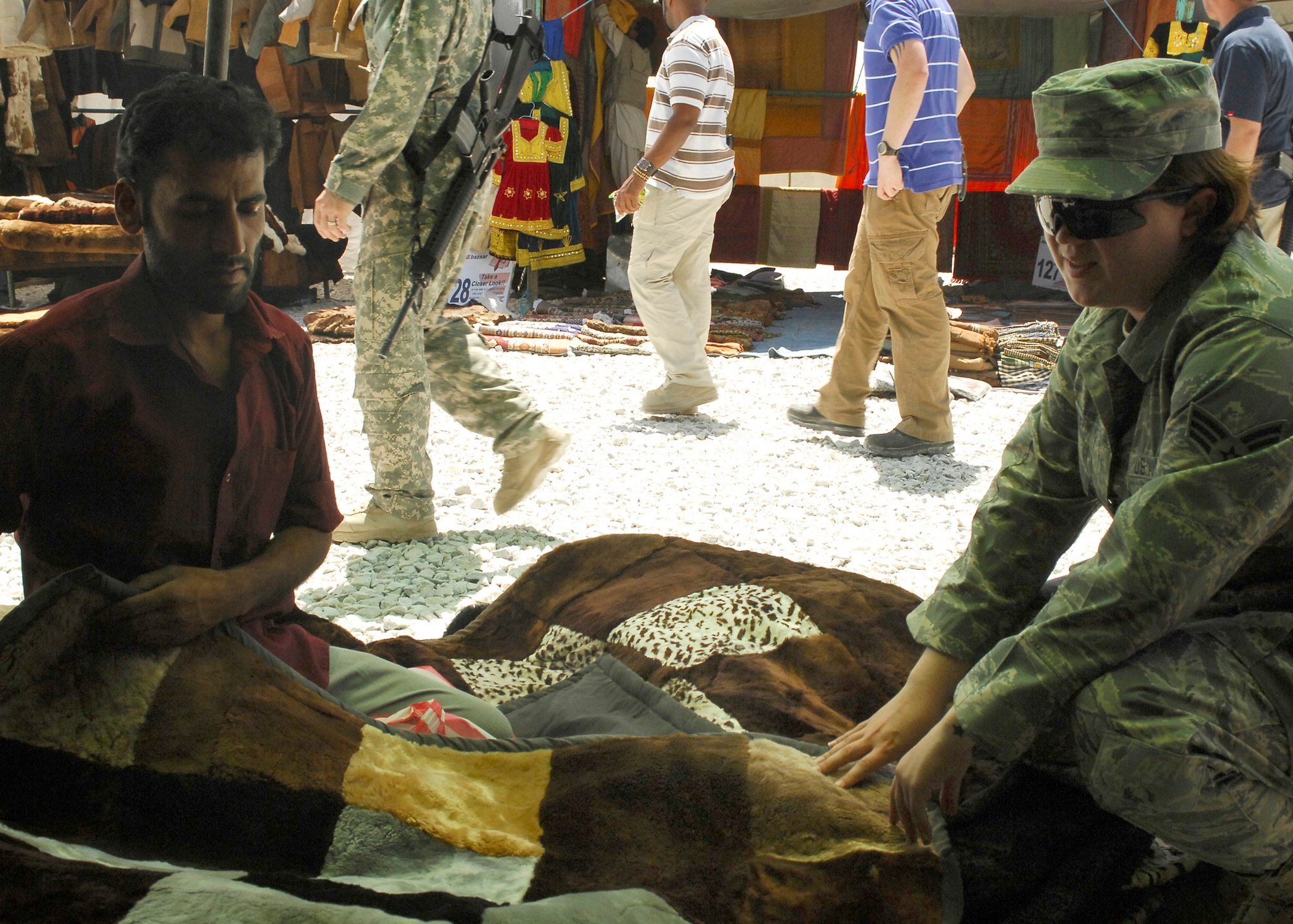 BAGRAM AIR FIELD, Afghanistan - A local vender haggles the price of a rug with Senior Airman Felicia Juenke, from the 455th Expeditionary Public Affairs Office, at the Bazaar, here July 17. The Bazaar just reopened and troops were very anxious to see what was in store. (U.S. Air Force photo/Senior Airman Susan Tracy)