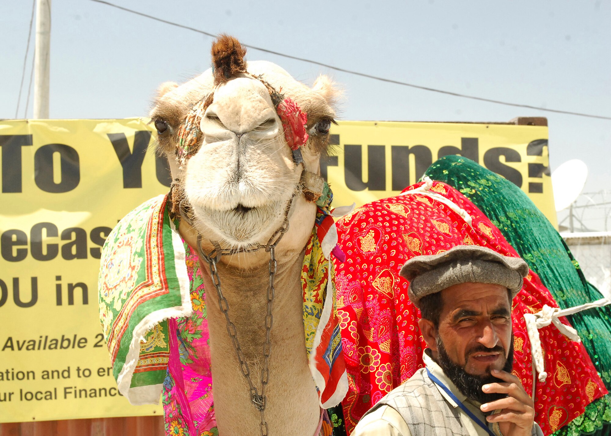 BAGRAM AIR FIELD, Afghanistan - A local vender offers pictures and rides on his camel at the Bazaar, here July 17. The Bazaar just reopened and troops were very anxious to see what was in store, the Bazaar is a place that allows the locals to make money by selling anything from rugs to camel rides. (U.S. Air Force photo/Senior Airman Susan Tracy)