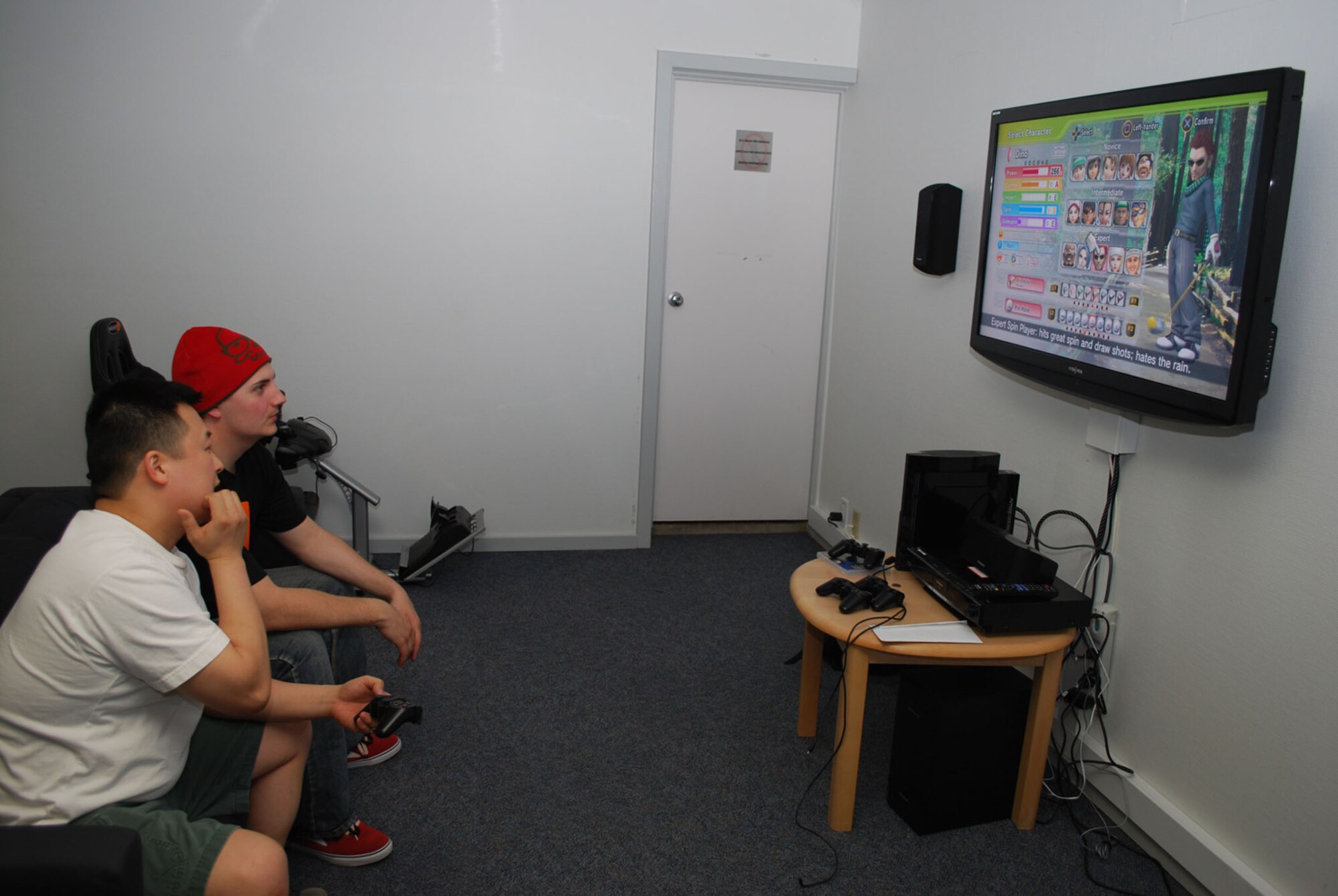 Staff Sgt. Woo Park, 821st Support Squadron medical flight, and Senior Airman Richard Armstrong, 821st Air Base Group finance, play a video game at the new Airman's Ministry Center in the community center July 10. Air Force Chapel Services and the 21st Space Wing funded the project which transformed an empty room in the community center into a free gaming center open to all of Team Thule (Photo by 1st Lt. Lisa Meiman).