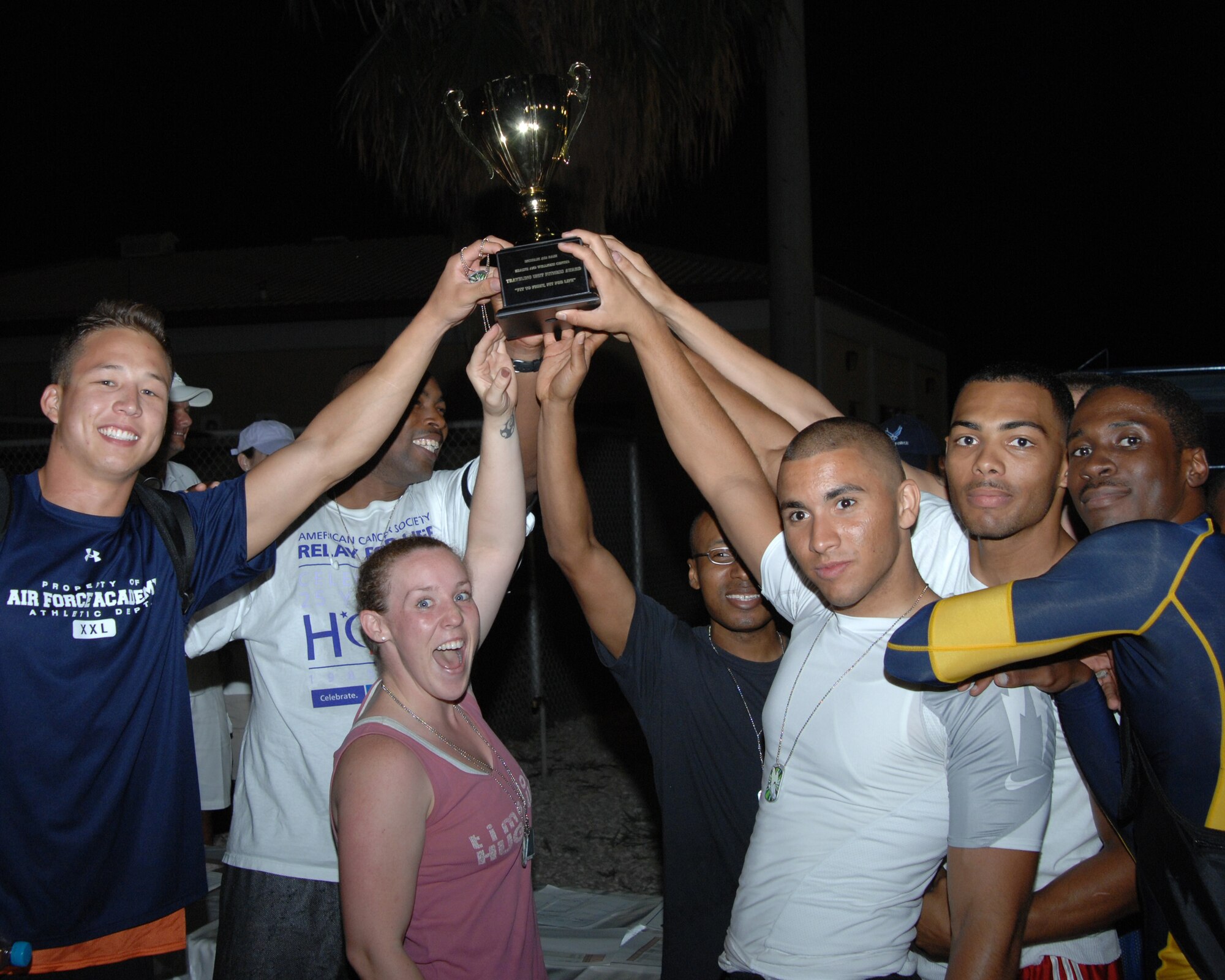 Members of the 728th Air Mobility Squadron hoist the Traveling Unit Fitness Award Wednesday, 25 July 2009 after beating out the other units competing in the Under the Lights Track Meet at Incirlik Air Base, Turkey. The event was sponsored by the Health and Wellness Center, the Sexual Assault Response Coordinator and the Fitness Center to promote fitness and increase base morale. Squadrons earned points throughout the event to determine the winner of the Travelling Unit Fitness Award. (U.S. Air Force photo/ Staff Sgt. Lauren Padden)