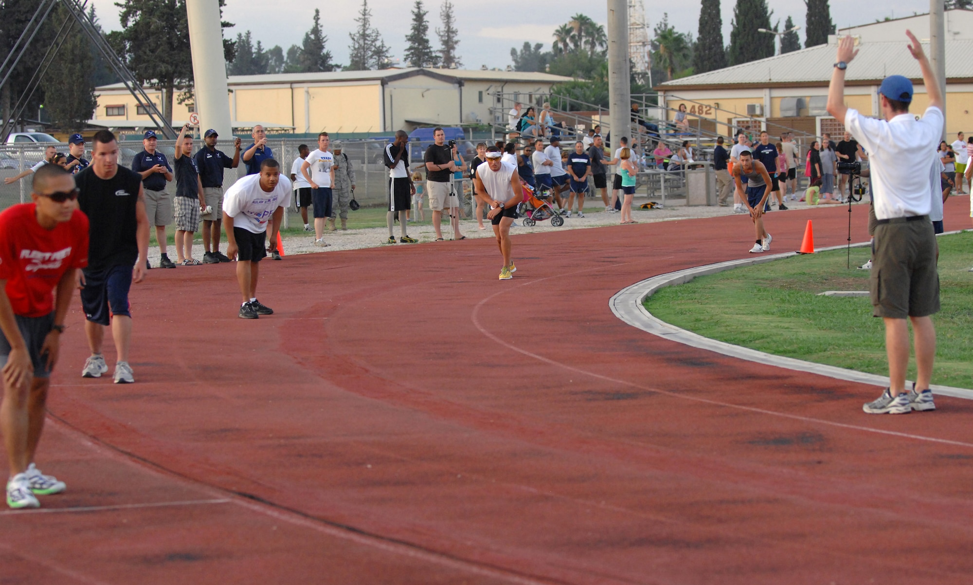 Members of Team Incirlik wait for the whistle to begin the 400 meter race Wednesday, 25 July 2009 during the Under the Lights Track Meet at Incirlik Air Base, Turkey. The event was sponsored by the Health and Wellness Center, the Sexual Assault Response Coordinator and the Fitness Center to promote fitness and increase base morale. Squadrons earned points throughout the event to determine the winner of the Travelling Unit Fitness Award. The winning squadron was the 728th Air Mobility Squadron. (U.S. Air Force photo/ Staff Sgt. Lauren Padden)