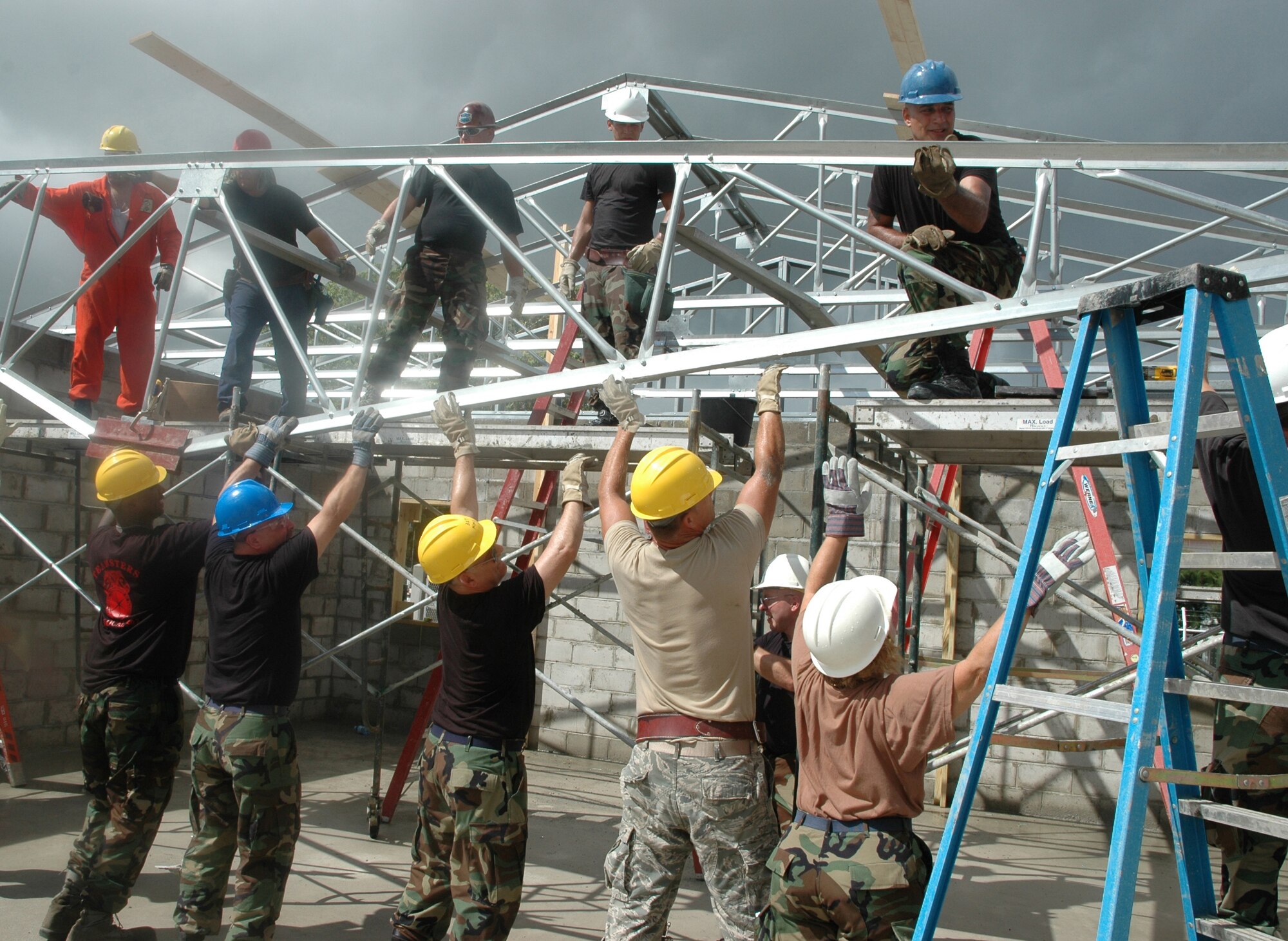 GEORGETOWN, GUYANA -- Air Force Reservists with the 910th Civil Engineer Squadron team up to install the next truss towards completion in the roof assembly for a new school.  The $230k school project is a joint effort in cooperation with the U.S. Army under U.S. Southern Command.  U.S. Air Force Photo by Major Brent J. Davis