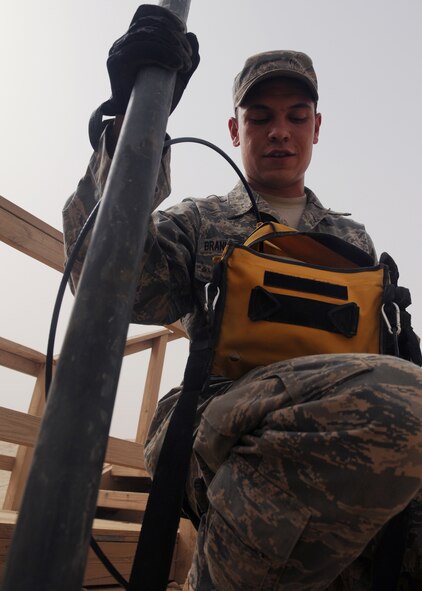 JOINT BASE BALAD, Iraq -- Senior Airman Frederick Branham-Claton of the 332nd Expeditionary Communications Squadron checks signal levels on a microwave antenna at the north entry control point here July 15. SrA Branham-Claton is responsible for maintaining and installing cables to keep networks up and running throughout the installation (U.S. Air Force photo/Senior Airman Christopher Hubenthal)