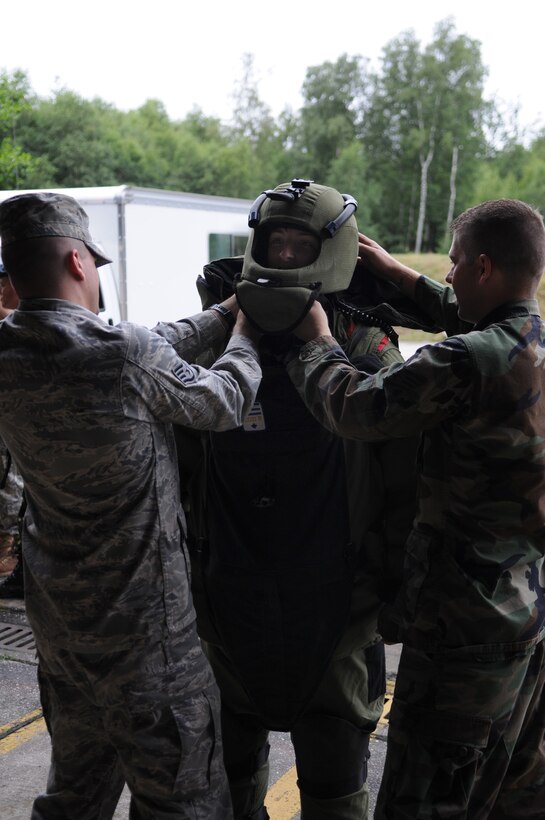 U.S. Air Force Staff Sgt.’s James Hodges and Dustin Jolman, 86th Construction and Training Squadron instructors, help British Air Cadet Sgt.  Andy Magee, 234th City of Durham, put on explosive ordnance disposal bomb-suit during the cadet’s visit to Ramstein Air Base, Germany, July 14, 2009. Cadets visited Ramstein for a week of leadership development and contingency skills training. (U.S. Air Force photo by Airman 1st Class Caleb Pierce)