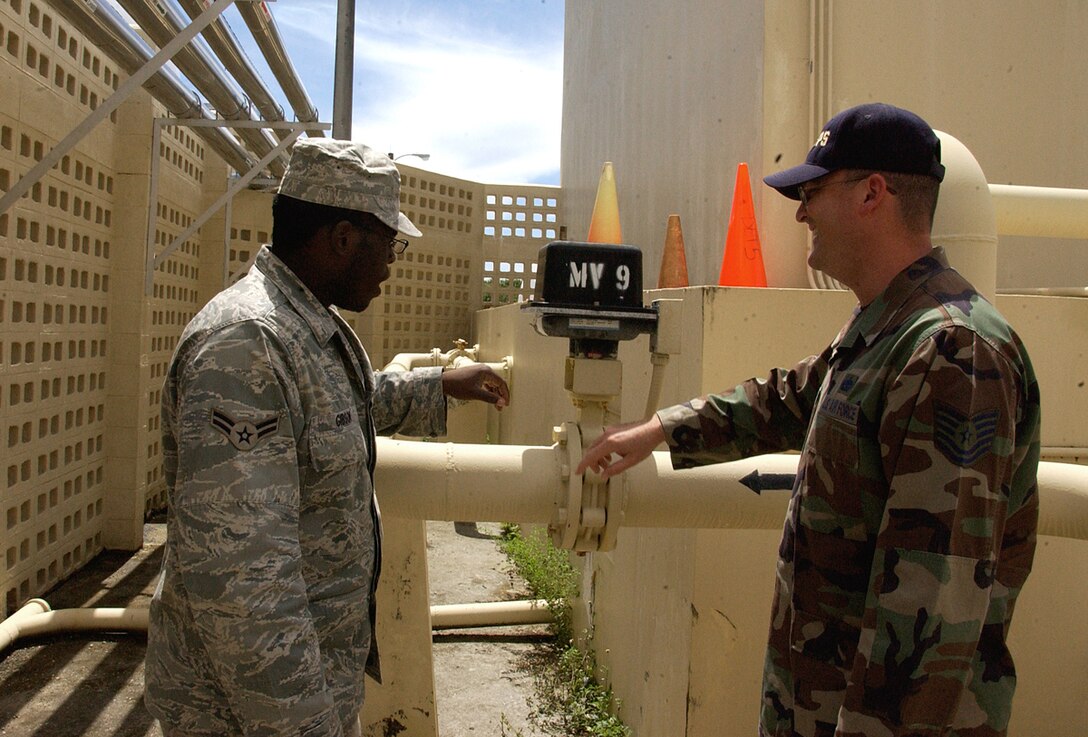ANDERSEN AIR FORCE BASE, Guam -- Airman 1st Class Kenneth Gibson, 36th Civil Engineer Squadron heating, ventilation and air conditioning technician, explains HVAC operating procedures to Tech. Sgt. Lee Galbraith, 22nd Space Operations Squadron, Detachment 5, at the Pacific Air Forces Regional Training Center at Northwest Field June 19. Sergeant Galbraith was chosen as a Top Performer by Maj. Eleanor Peredo, 22nd SOPS, Det. 5 commander, for his dedication and outstanding performance in his duties. (U.S. Air Force photo by Airman Carissa Wolff)