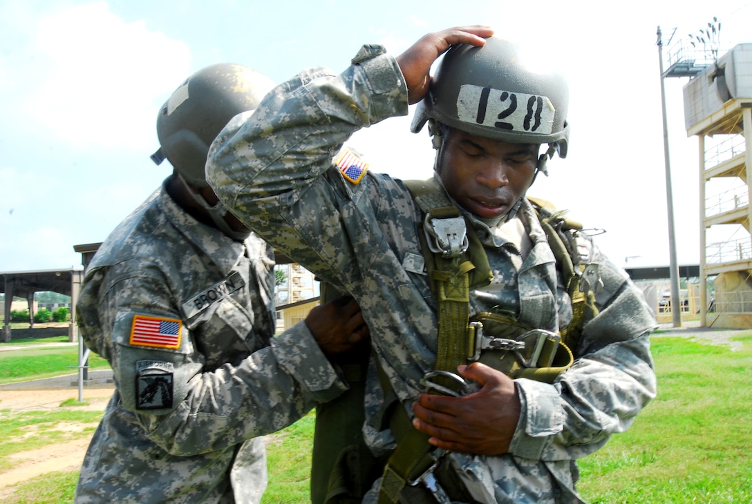 U.S. Army Spc. Ian Brown, left, helps Pvt. Andrew Brown put on his harness at the Army Airborne School during the first phase of parachute training known as "ground week" on Fort Benning, Ga., July 8, 2009. The soldiers, assigned to Company B, 1st Battalion, 507th Parachute Infantry Regiment, learned how to wear their equipment and practiced parachute landing falls.