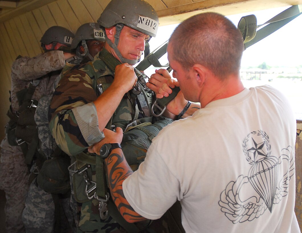 U.S. Army Staff Sgt. William Wallace, right, an instructor known as a "black hat," secures a static line to the harness of U.S. Navy Petty Officer 1st Class Richard Hubez-Chartraw at the Army Airborne School on Fort Benning, Ga., July 8, 2009. Wallace is assigned to Company B, 1st Battalion, 507th Parachute Infantry Regiment.