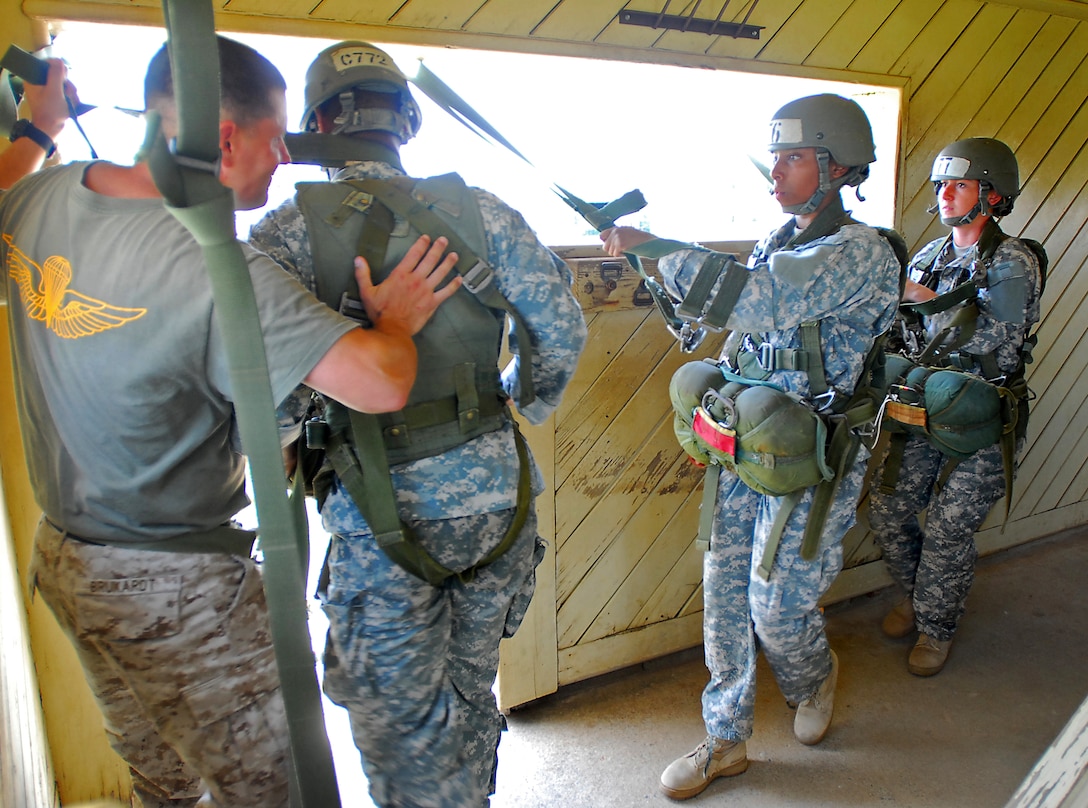 U.S Marine Corps Staff Sgt. Robert Brukardt, left, an instructor known as a "black hat," pushes soldiers out the door from the tower during the second phase of parachute training known as "tower week" at the Army Airborne School on Fort Benning, Ga., July 8, 2009. Brukardt is assigned to Company B, 1st Battalion, 507th Parachute Infantry Regiment.