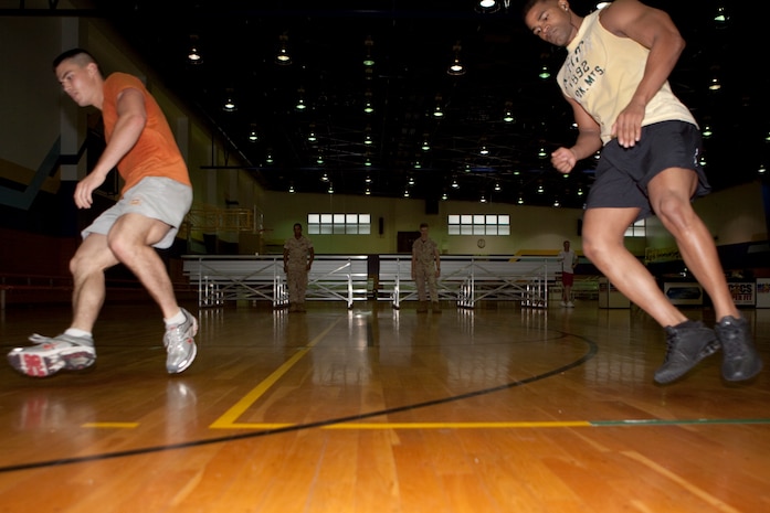 Kevin Chang (left), representing Marine Aviation Logistics Squadron 12, and Dominique Laboy hang neck and neck during the shuttle run portion of the Fitness Skills Challenge, part of the 2009 Commander’s Cup Challenge, at IronWorks Gym here July 17. Scores for the shuttle run proved the event to be more or less an equal playing field for everyone participating as most teams’ overall repetitions varied by 4 or less.