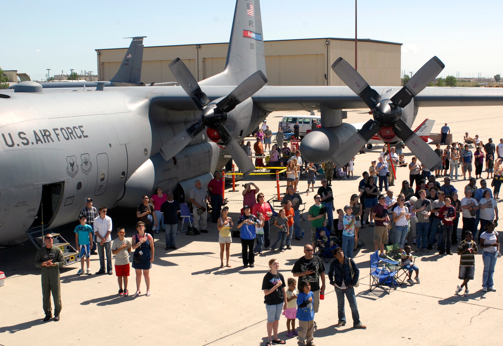 MINOT AIR FORCE BASE, N.D. --Spectators pay tribute to the National Anthem during the 2009 Northern Neighbors Day here July 18. Thousands of people turned out to watch the 2009 Northern Neighbors Day, which came through on its promise to wow spectators with amazing aerial maneuvers, nail-biting choreography, historic displays and much more. (U.S. Air Force Photo by Airman 1st Class Jesse Lopez)