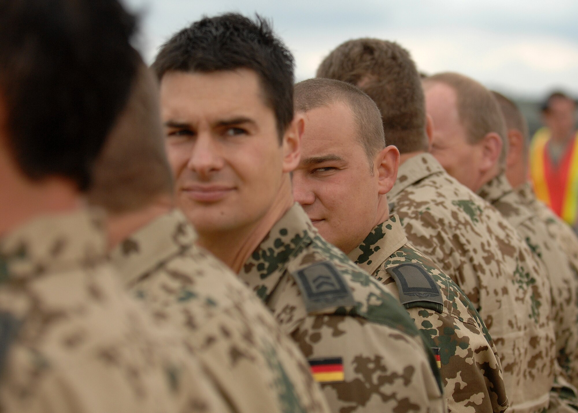 Two German Air Force members watch the arrival of their German C-130 Aircraft standing in formation during the international competitor arrivals for AMC Rodeo 2009, McChord AFB, WA, July 13, 2009. RODEO is an international combat skills and flying operations competition designed to develop and improve techniques and procedures with our international partners to enhance mobility operations (U.S. Air Force photo by SSgt Stephen Schester/Released)  