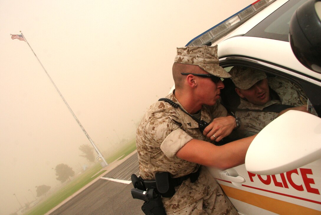Military policemen Lance Cpl. Kevin Mathias, left, and Lance Cpl. Kyle Schmitt plan their patrol routes after raising the storm flag amidst a sandstorm that swept over the Marine Corps Air Station in Yuma, Ariz., July 18, 2009. “We change the flag any time we get a high wind or storm warning,” said Staff Sgt. Dustin Schellenger, provost marshal’s office operations chief. The storm, which lasted approximately one hour, averaged winds of 32.2 mph with gusts of 43.7 mph, according to the station weather office.