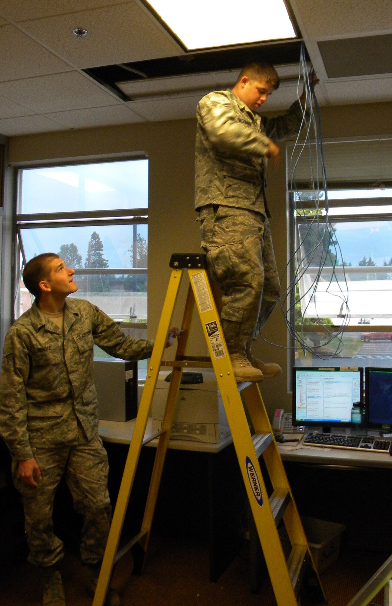 Senior Airmen Uriah Beagle and Kenneth Treadway wire cables in the ceiling in preperation for the Air Mobility RODEO July 19, 2009. RODEO is an international combat skills and flying operations competition designed to develop and improve techniques and procedures with our international partners to enhance mobility operations.  Airmen Beagle and Treadway are assingend to the 62nd Communications Squadron, McChord Air Force Base, Wash. (U.S. Air Force photo/Tech. Sgt. Rease Wold)