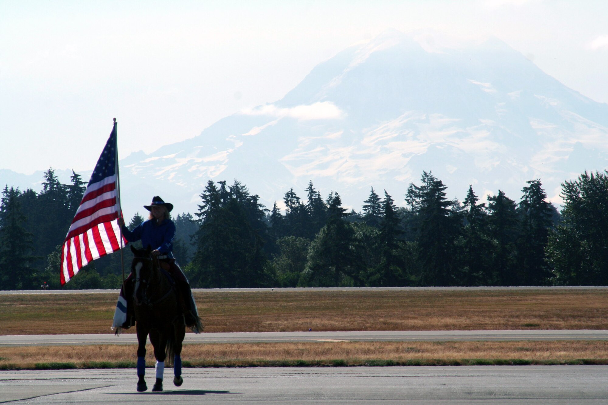 A horse rider carries in the American flag for the opening ceremonies for Air Mobility Command's RODEO 2009 July 19 at McChord Air Force Base, Wash.  More than 100 teams are participating in RODEO competition, including teams from seven foreign countries. RODEO is the U.S. Air Force's and AMC's premier air mobility competition. It's an international combat skills and flying operations competition designed to develop and improve techniques, procedures and interoperability with international partners to optimize mobility partnerships and enhance mobility operations. (U.S. Air Force Photo/Tech. Sgt. Scott T. Sturkol)