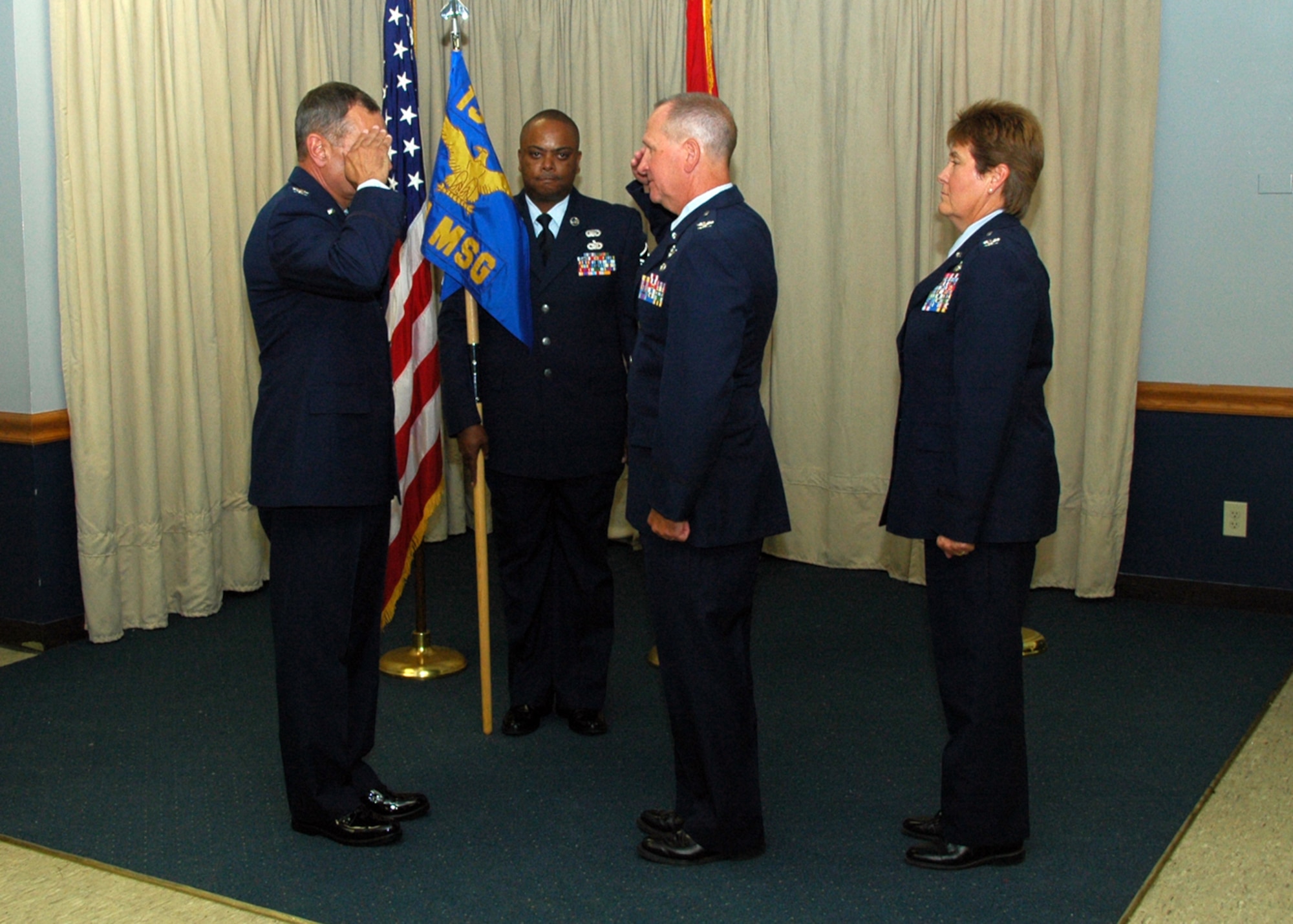 Colonel Keith Smith renders a final salute to Colonel Robert Leeker, 131 Bomb Wing Commander, during the Mission Support Group Change of Command ceremony, in which Colonel Terri Chaney (far right) assumed command, July 18.   (Photo by Master Sgt. Mary-Dale Amison)