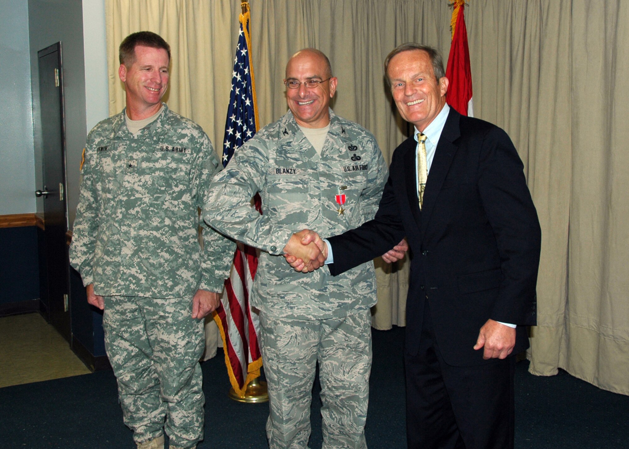 Congressman Todd Akin (R-MO) congratulates Colonel Paul Blanzy of the 231 Civil Engineering Flight-Missouri Air National Guard, on his award of the Bronze Star Service Medal on July 18, while Brigadier General David Irwin, Commander 35th Engineer Brigade-Missouri Army National Guard, looks on.  Colonel Blanzy received the Bronze Star for meritorious service with the U.S. Army at Forward Operating Base Salerno, Khost, Afghanistan from July 2008 - January 2009.  (Photo by Master Sgt. Mary-Dale Amison)