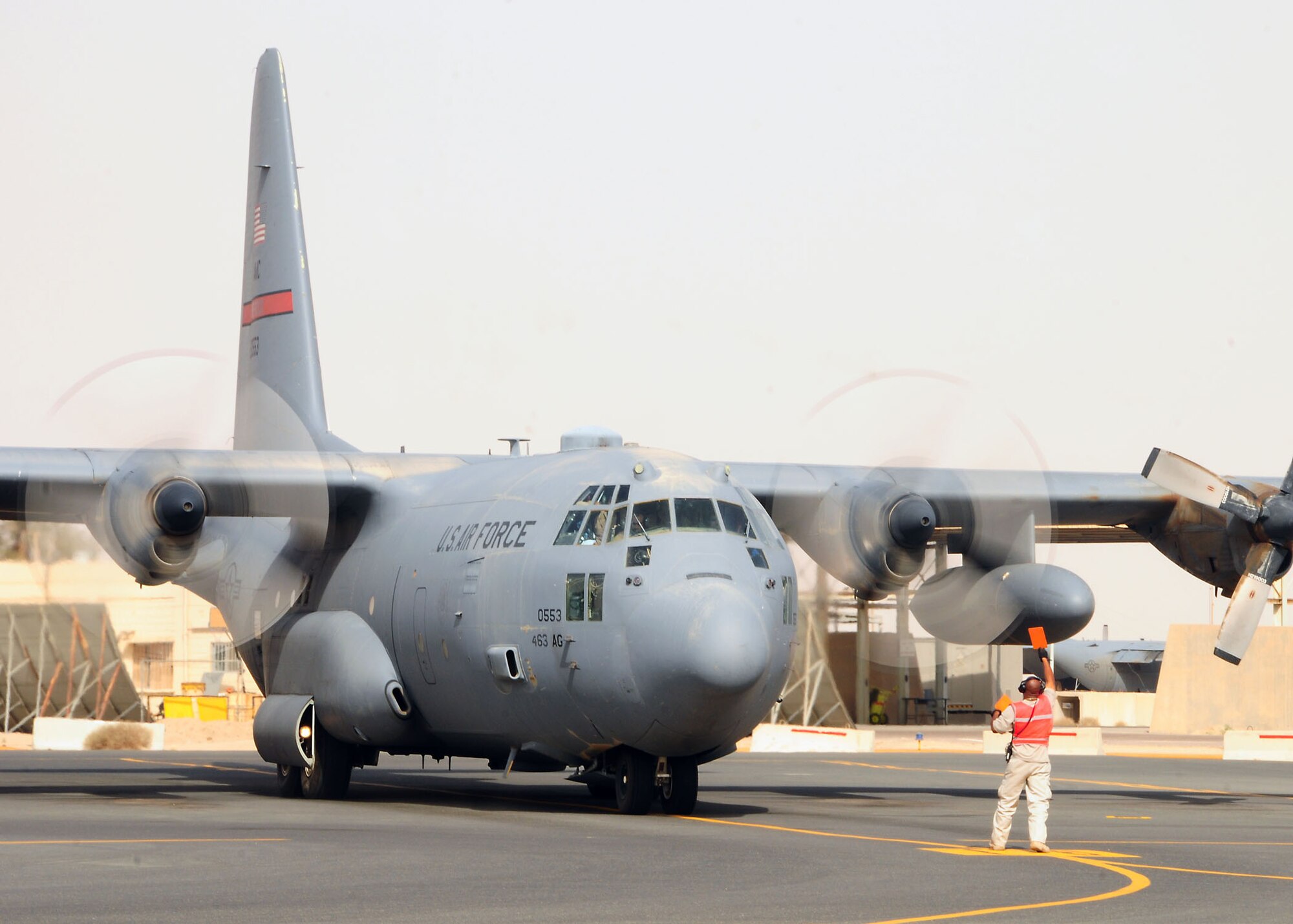 A C-130 Hercules is marshaled into position at the 386th Air Expeditionary Wing parking ramp at an undisclosed location in Southwest Asia July 18.  The aircraft is assigned to the 777th Expeditionary Airlift Squadron, Joint Base Balad, Iraq and is deployed from the 189th Airlift Wing, Little Rock Air Force Base, Ark.  (U.S. Air Force photo/Tech Sgt. Tony Tolley)