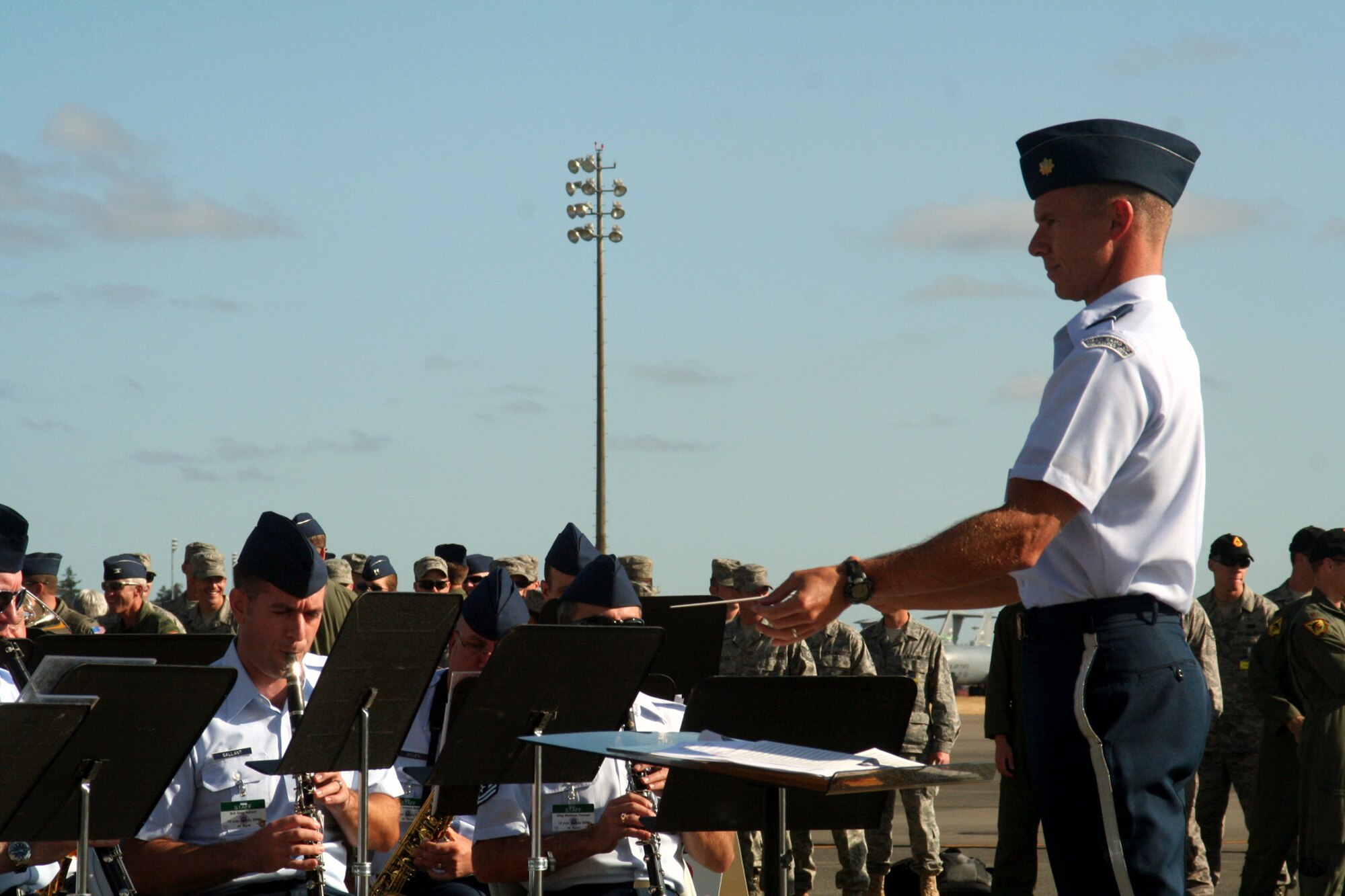 Maj. Keith Bland, conductor/commander of the Air Force's Band of the Golden West of Travis Air Force Base, Calif., leads direction of the band as they play during the opening ceremonies for Air Mobility Command's RODEO 2009 July 19 at McChord Air Force Base, Wash.  More than 100 teams are participating in RODEO competition, including teams from seven foreign countries. RODEO is the U.S. Air Force's and AMC's premier air mobility competition. It's an international combat skills and flying operations competition designed to develop and improve techniques, procedures and interoperability with international partners to optimize mobility partnerships and enhance mobility operations. (U.S. Air Force Photo/Tech. Sgt. Scott T. Sturkol)