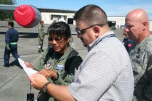 Mr. Jeff Michalke, Air Mobility Command's coordinator for the Air Force Art Program at Scott Air Force Base, Ill., who is leading a group of four artists who are observing competition for Air Mobility RODEO 2009, talks with RODEO umpires July 20 at McChord AFB, Wash. More than 100 teams are participating in RODEO competition, including teams from seven foreign countries. RODEO is the U.S. Air Force's and AMC's premier air mobility competition. It's an international combat skills and flying operations competition designed to develop and improve techniques, procedures and interoperability with international partners to optimize mobility partnerships and enhance mobility operations. (U.S. Air Force Photo/Tech. Sgt. Scott T. Sturkol)