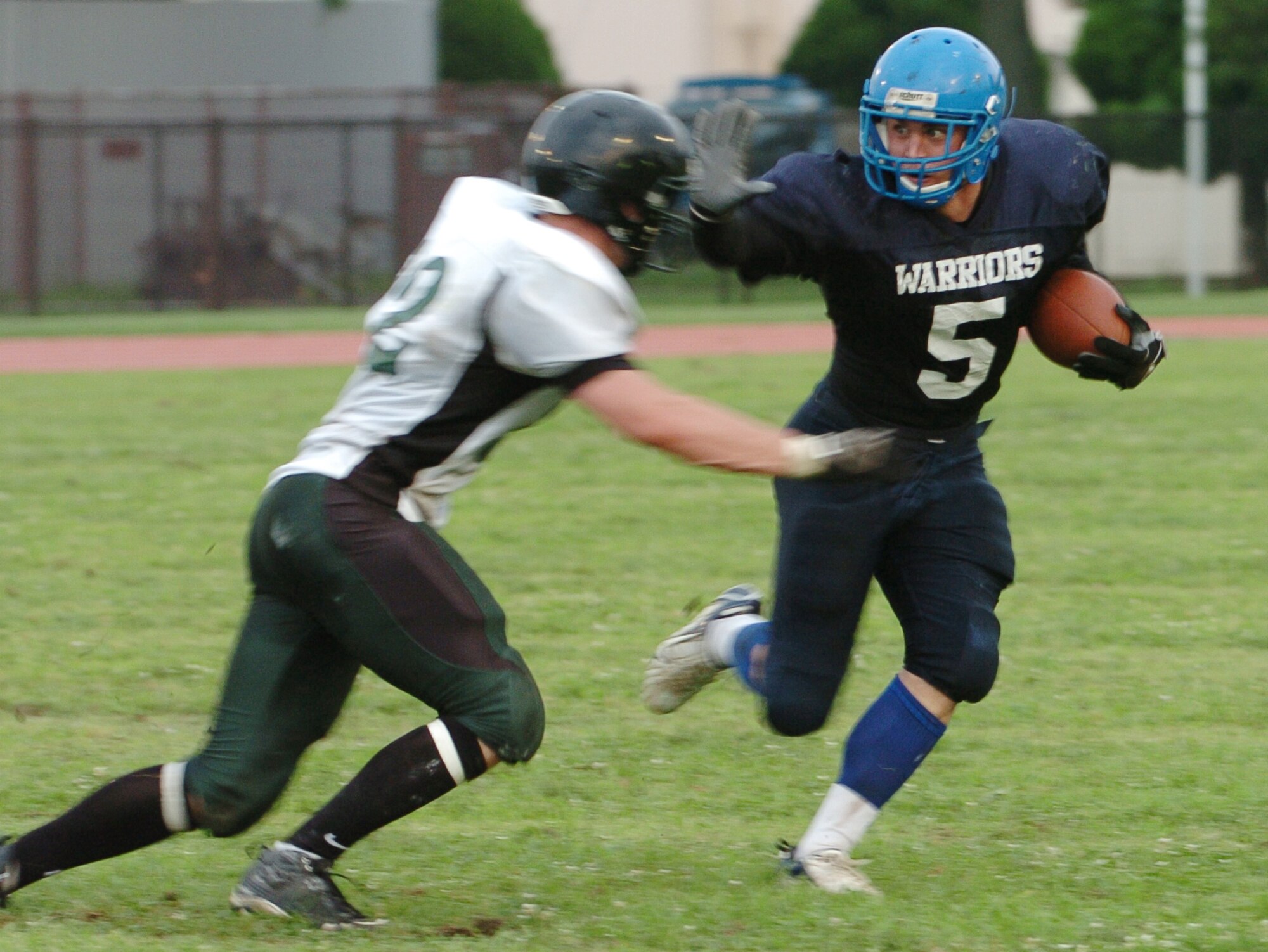 YOKOTA AIR BASE, Japan -- Yokota Warriors' running back Kevin Fortin stiff arms a Misawa Jets' defender during Yokota's 44-12 defeat of the Jets July 18 in the first round of the U.S. Forces Japan-American Football League playoffs at Bonk Field. The Warriors scored three defensive touchdowns in the first half to put the game out of reach early. Yokota travels to Yokosuka Aug. 1 to take on the Seahawks at 7 p.m. (U.S. Air Force photo/Master Sgt. Matt Summers