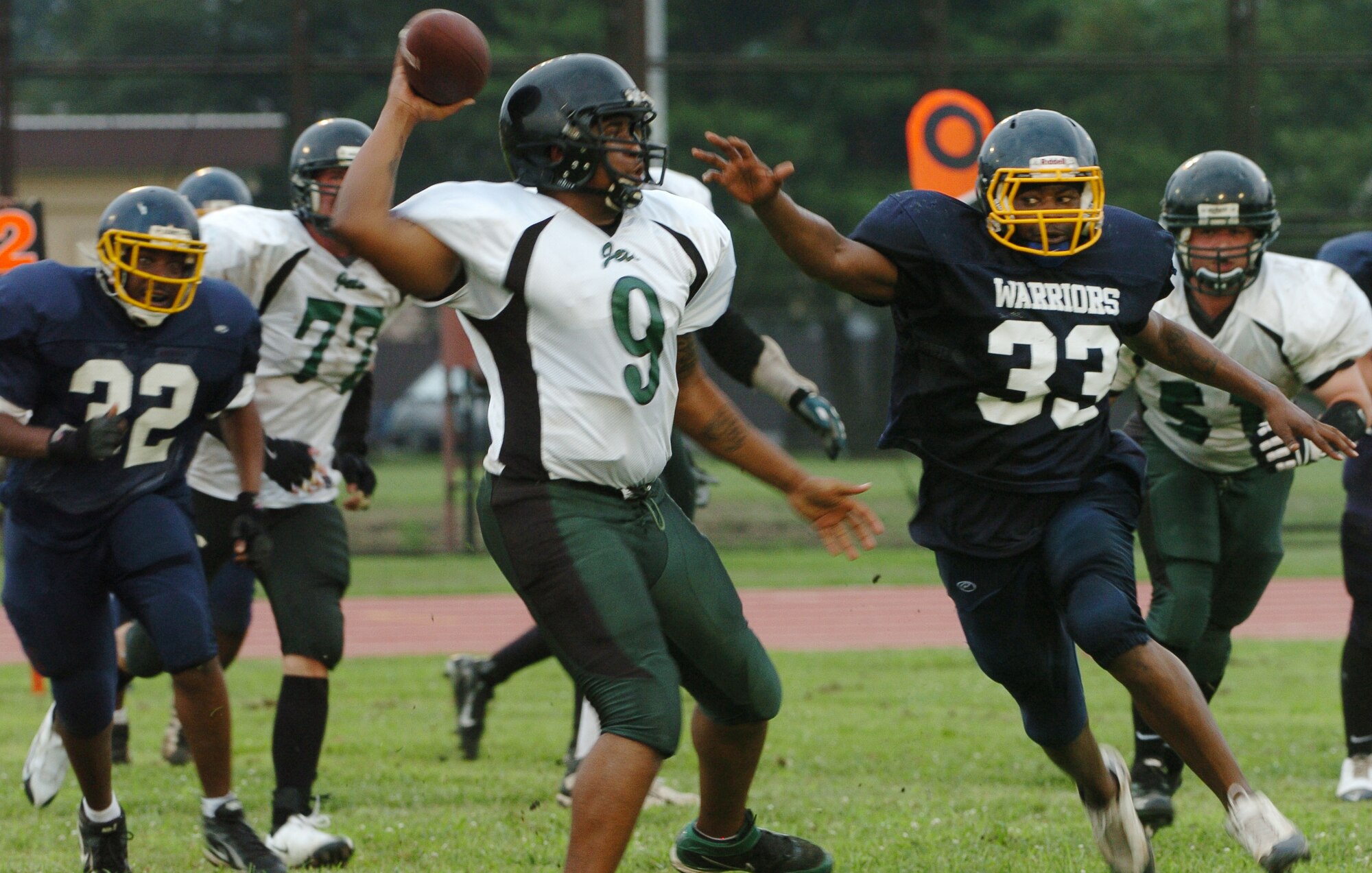YOKOTA AIR BASE, Japan -- Yokota Warriors' linebacker Tabari Thompson (No. 33) puts pressure on Misawa Jets' quarterback Daron Frierson during the second quarter of Yokota's 44-12 defeat of the Jets July 18 in the first round of the U.S. Forces Japan-American Football League playoffs at Bonk Field. Frierson was 31-47 for 315 yards and two touchdowns in a losing effort. The Warriors scored three defensive touchdowns in the first half to seal the win. Yokota travels to Yokosuka Aug. 1 to take on the Seahawks at 7 p.m. (U.S. Air Force photo/Master Sgt. Matt Summers)