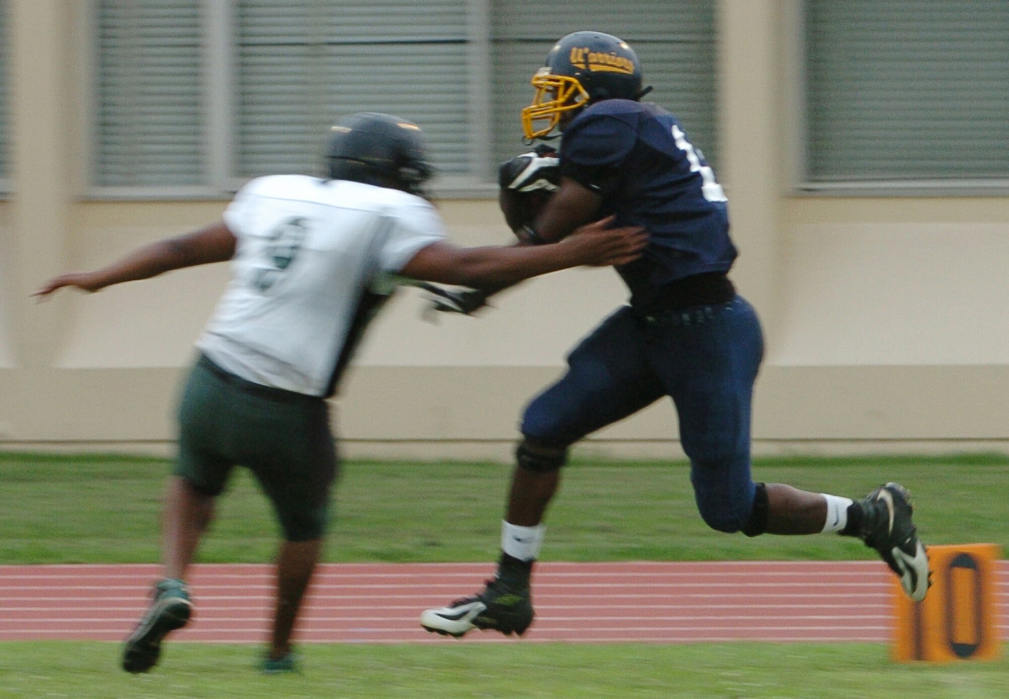 YOKOTA AIR BASE, Japan -- Yokota Warriors' linebacker Donald White runs through the arm tackle of Misawa Jets' quarterback Daron Frierson on his way to the end zone after an interception during the second quarter of Yokota's 44-12 defeat of the Jets July 18 in the first round of the U.S. Forces Japan-American Football League playoffs at Bonk Field. White returned an interception and a fumble for TDs in the first half. Yokota travels to Yokosuka Aug. 1 to take on the Seahawks at 7 p.m. (U.S. Air Force photo/Master Sgt. Matt Summers)