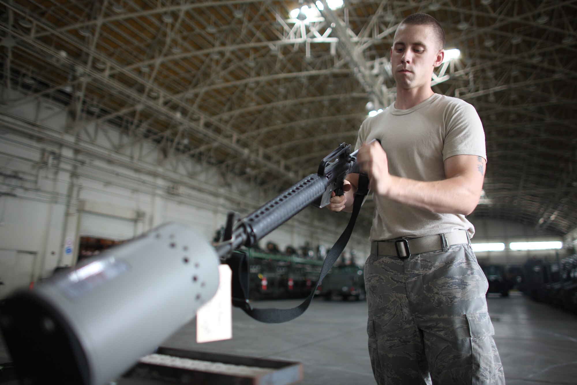 YOKOTA AIR BASE, Japan -- Airman 1st Class Bruce Parker, 374th Logistics Readiness Squadron, inspects an M-16 rifle in the squadron's mobility warehouse to ensure the weapon is not loaded before cleaning it July 20. The 374th LRS Individual Protective Equipment Issue Section maintains and provides equipment to Yokota Airmen for use during training exercises and real-world deployments. (U.S. Air Force photo/Osakabe Yasuo)