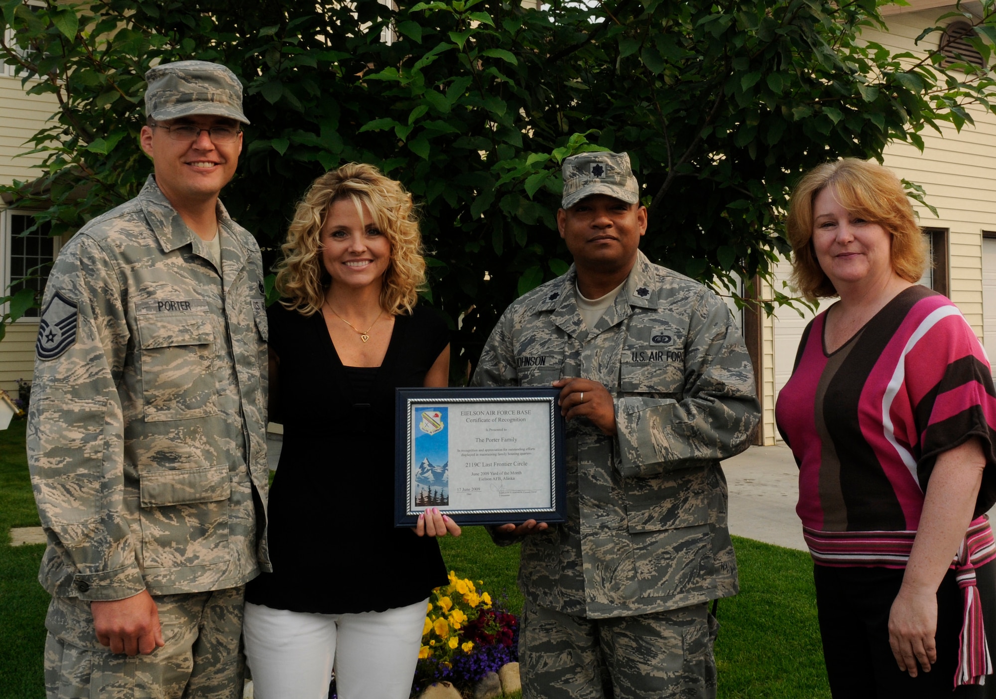 Master Sgt. Justin Porter and wife Leanna display their Home Your Proud of Award with Lt. Col. Jesse Johnson and Lorie Dallas July 14, 2009 Eielson Air Force Base, Alaska. Sergeant Porter and his family are winners for area 1. Each winning houshold recieved gift cards from variouse units off base. Sergeant Porter is the superintendent of the water systems with the 354th Civil Engineering Squadron, Colonel Johnson is the 354th Mission Support Group deputy commander, and Ms. Dallas, 354th CES
military family housing chief of capital asset management. (U.S. Air Force photo/Airman 1st Class Laura Goodgame)