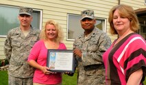 Staff Sgt. Michael Duell and wife Stephanie display their Home Your Proud of Award with Lt. Col Jesse Johnson, and Lorie Dallas, July 14, 2009 Eielson Air Force Base, Alaska. Sergeant Duell and his family are winners for area 2. Each winning houshold recieved gift cards from variouse units off base. Sergeant Duell is with the 354th Comptrollers Squadron, Colonel Johnson is the 354th Mission Support Group deputy commander, and Ms. Dallas, 354th CES military family housing chief of capital asset management. (U.S. Air Force photo/Airman 1st Class Laura Goodgame)