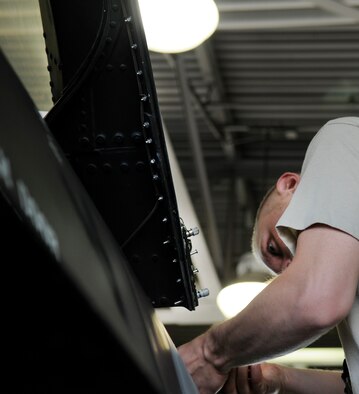 Airman 1st Class Blake Newberry performs pre-flight inspections under newly installed light bulbs July 13 at Eielson Air Force Base, Alaska. The new lights in the F-16 bays' provide more illumination making it easier for maintenance technicians to see what they are doing without the use of a flashlight. (U.S. Air Force photo/Airman 1st Class Laura Goodgame) 