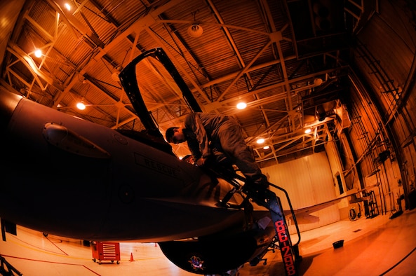Airman 1st Class Julio Oseguera performs pre-flight inspections under outdated lighting July 13 at Eielson Air Force Base, Alaska. The lights were providing inefficient lighting for the maintenance technicians to work under without the use of a flashlight. Airman Oseguera is an assistant dedicated crew chief with the 354th Aircraft Maintenance Squadron. (U.S. Air Force photo/Airman 1st Class Laura Goodgame) 