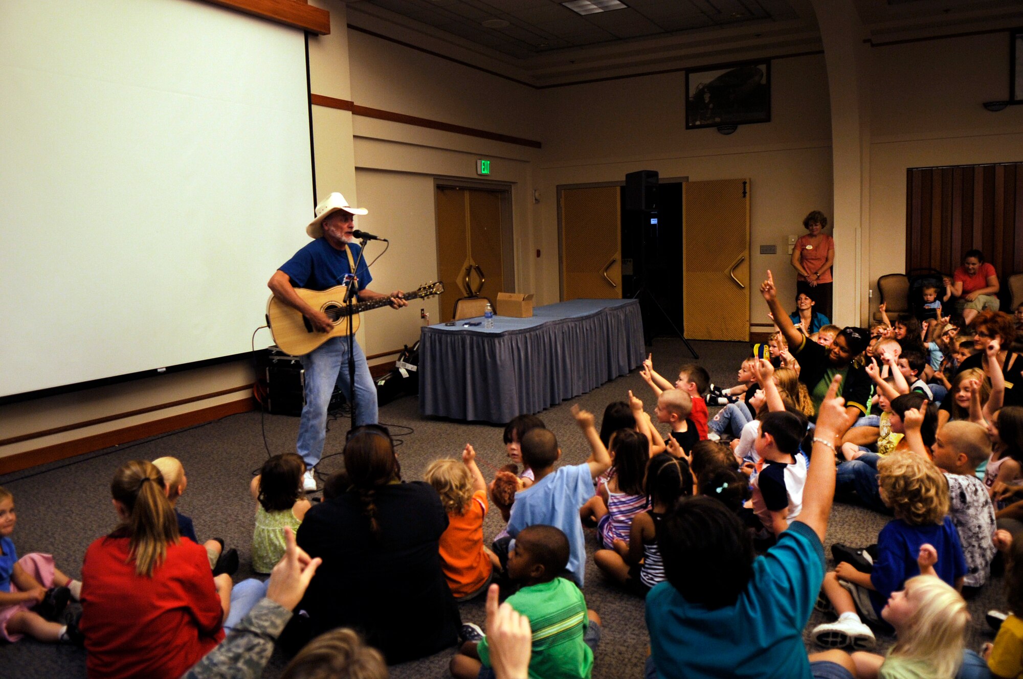 Children along with staff of the Eielson Air Force Base Child Development Center sing along with Hobo Jim during a free summer concert at the Aurora Club July 14, 2009. Hobo Jim performed the free concert as a way to say thank you Airmen and their families for their service. (U.S. Air Force photo/Airman 1st Class Laura Goodgame)
