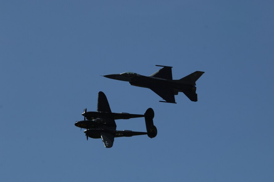 MINOT AIR FORCE BASE, N.D. -- A P-38 Lightning and F-16 Falcon demonstrate the U.S. Air Force Heritage Flight during the 2009 Northern Neighbors Day festivities here July 18. Thousands of people from the base and local community turned out to watch the 2009 Northern Neighbors Day, which came through on its promise to wow spectators with amazing aerial maneuvers, nail-biting choreography, historic displays and much more.   (U.S. Air Force photo by Tech. Sgt.  Lee A. Osberry Jr.)
