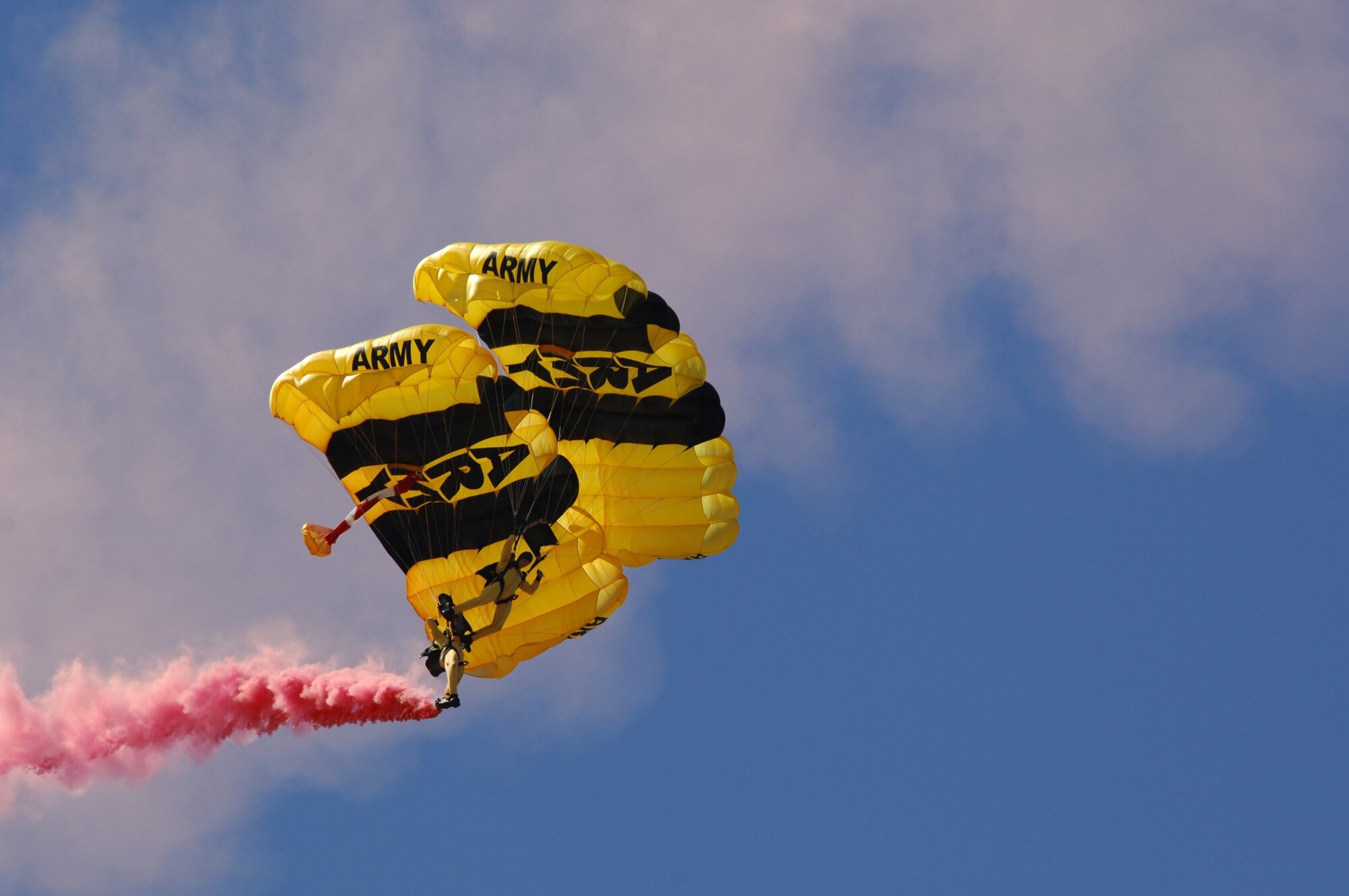 MINOT AIR FORCE BASE, N.D. -- Members from the U.S. Army Golden Knight parachute team descends on the base displaying the Canadian flag during the 2009 Northern Neighbors Day opening ceremony here July 18. Thousands of people from the base and local community turned out to watch the 2009 Northern Neighbors Day, which came through on its promise to wow spectators with amazing aerial maneuvers, nail-biting choreography, historic displays and much more.   (U.S. Air Force photo by Tech. Sgt.  Lee A. Osberry Jr.)