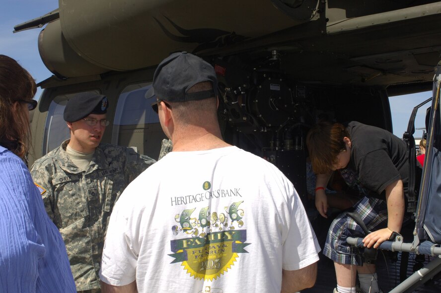 MINOT AIR FORCE BASE, N.D. -- Pfc. Nathaniel Cheek, 2285th Assault Unit crew chief, talks about the capabilities of the UH-60 Black Hawk during the 2009 Northern Neighbors Day festivities here July 18. Thousands of people from the base and local community turned out to watch the 2009 Northern Neighbors Day, which came through on its promise to wow spectators with amazing aerial maneuvers, nail-biting choreography, historic displays and much more.   (U.S. Air Force photo by Tech. Sgt.  Lee A. Osberry Jr.)