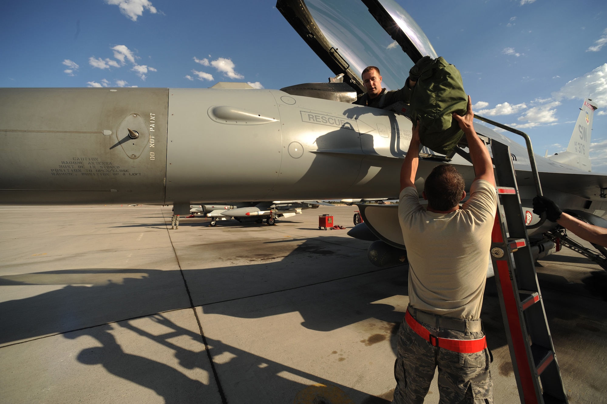 Capt. Taylor Blevins, 77th Fighter Squadron hands his helmet bag to his Crew Chief Staff Sgt. William Reeder after returning from a training mission at Red Flag 09-4, Nellis Air Force Base, Nev.,  July 16, 2009. Red Flag is a highly-realistic combat training exercise that pits U.S. and allied nation air forces against 'enemy' forces in a challenging air, ground, cyberspace and electronic threat environment. (U.S. Air Force Photo/Tech. Sgt. Michael R. Holzworth)