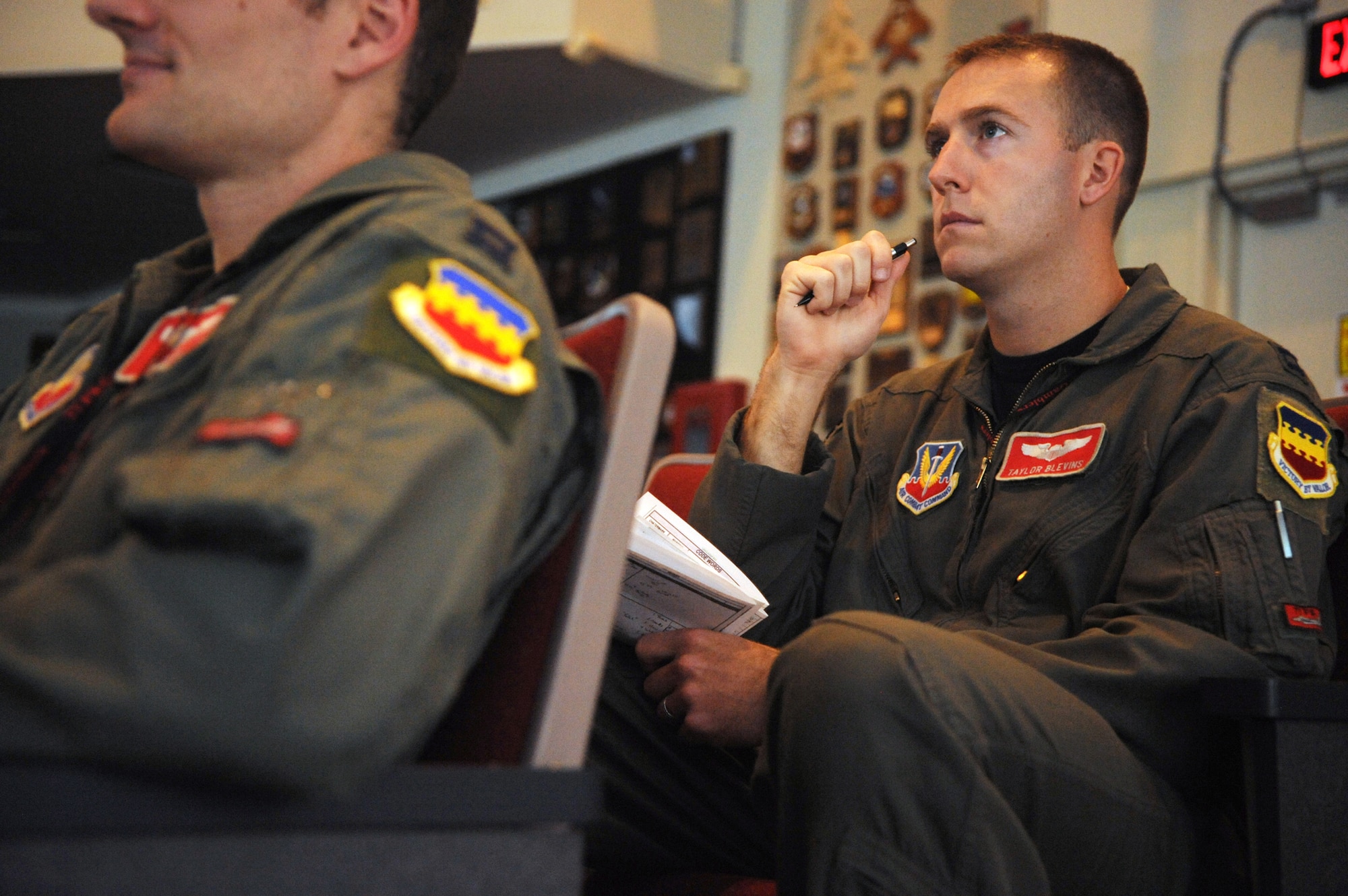 Capt. Taylor Blevins, 77th Fighter Squadron sits in the mass briefing facility with approximately 50 U.S. and allied nation pilots  at Red Flag 09-4, Nellis Air Force Base, Nev.,  July 16, 2009. Mass briefings can last more than an hour and provide pilots with vital information for their simulated combat scenarios. Red Flag is a highly-realistic combat training exercise that pits U.S. and allied nation air forces against 'enemy' forces in a challenging air, ground, cyberspace and electronic threat environment. (U.S. Air Force Photo/Tech. Sgt. Michael R. Holzworth)

