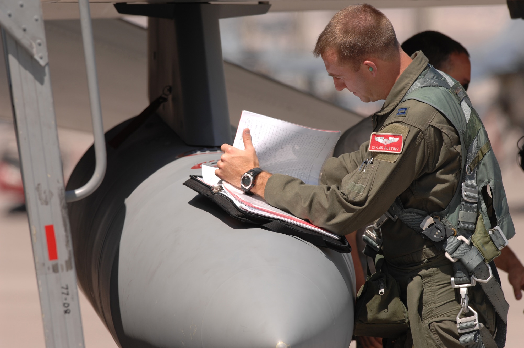 Capt. Taylor Blevins, 77th Fighter Squadron reviews and signs off pre-flight paperwork before getting into a F-16CJ and departing for a training mission at Red Flag 09-4, Nellis Air Force Base, Nev., on July 16, 2009. Red Flag is a highly-realistic combat training exercise that pits U.S. and allied nation air forces against 'enemy' forces in a challenging air, ground, cyberspace and electronic threat environment. (U.S. Air Force Photo/Tech. Sgt. Michael R. Holzworth)
