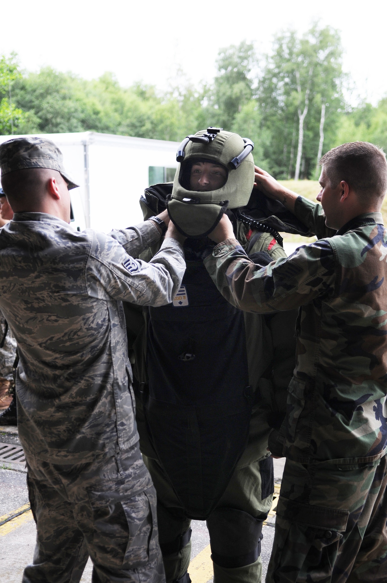 Staff Sgts. James Hodges and Dustin Jolman help British Air Cadet Sgt. Andy Magee put on an explosive ordnance disposal bomb suit during the cadet's July 14 visit to Ramstein Air Base, Germany. Cadets visited Ramstein AB for a week of leadership development and contingency skills training. Sergeants Hodges and Jolman are 86th Construction and Training Squadron instructors. (U.S. Air Force photo/Airman 1st Class Caleb Pierce) 
