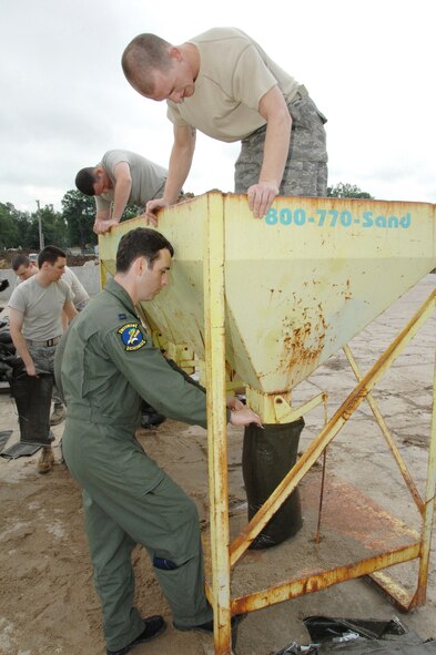 OFFUTT AIR FORCE BASE, Neb. -- Senior Airman Thomas Hester, 55th Security Forces Squadron, pushes sand into a bag held by Capt. Mike McDowell, 45th Reconnaissance Squadron during combat day here July 14. U.S. Air Force Photo by Dana Heard