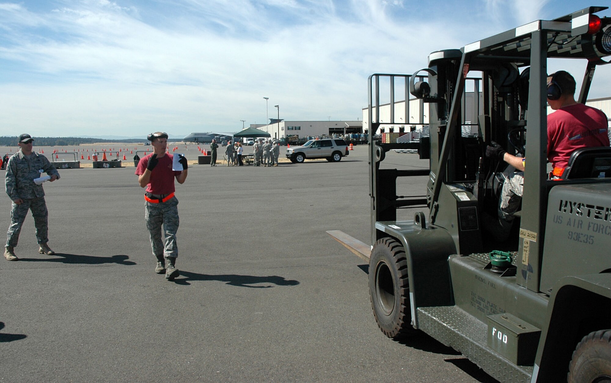From the 446th Airlift Wing Rodeo team, Tech. Sgt. Joshua Warbiany directs Staff Sgt. Ben Thomsen in the 10K Forklift event July 20 at the Air Mobility Command Rodeo, McChord Air Force Base, Wash.  The 446th Airlift Wing is the Reserve C-17 wing at McChord. (U.S. Air Force photo/Tech. Sgt. Jake Chappelle)