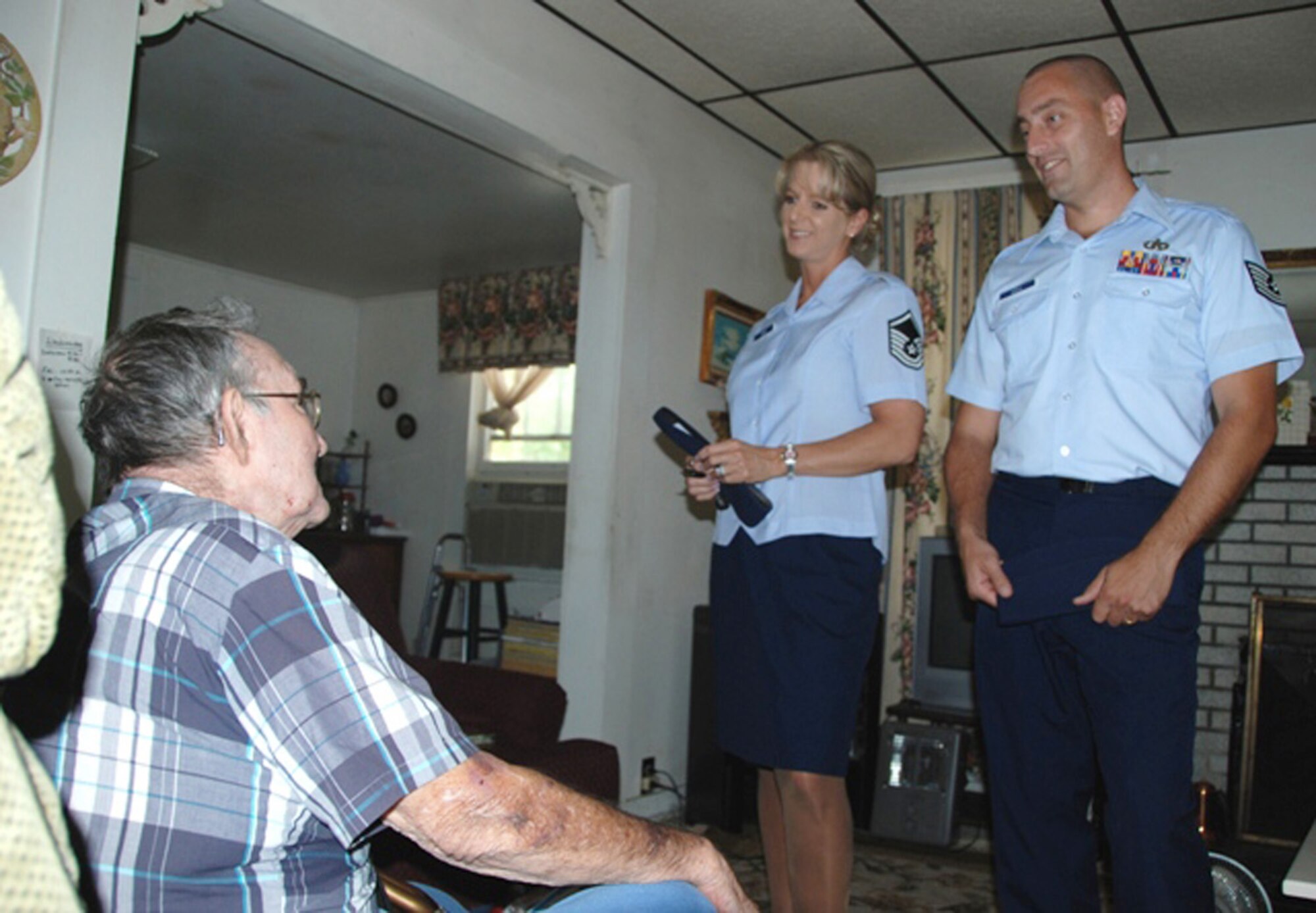 Master Sgt. Wendy Gehri and Tech. Sgt. Joe Ezell, members of the 601st Air and Space Operations Center at Tyndall Air Force Base, Fla., visit with Mr. Laurice Hand after delivering food to his house as a part of the local Bay County Council on Aging Meals on Wheels program.  (U.S. Air Force photo/1st Lt. Jared Scott)