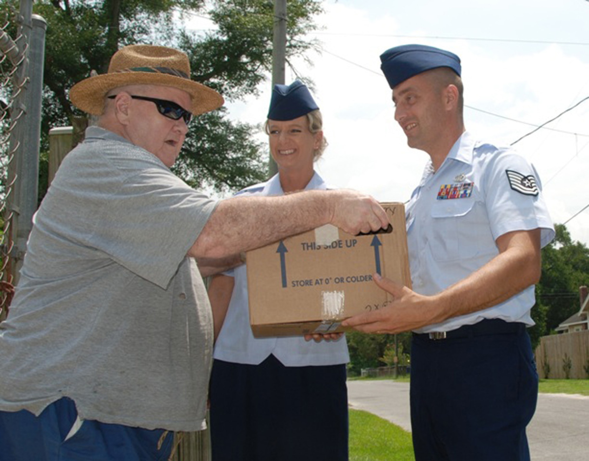 Master Sgt. Wendy Gehri and Tech. Sgt. Joe Ezell, members of the 601st Air and Space Operations Center at Tyndall Air Force Base, Fla., deliver meals to Mr. Edwin Terry as part of the local Bay County Council on Aging Meals on Wheels program.  (U.S. Air Force photo/1st Lt. Jared Scott) 