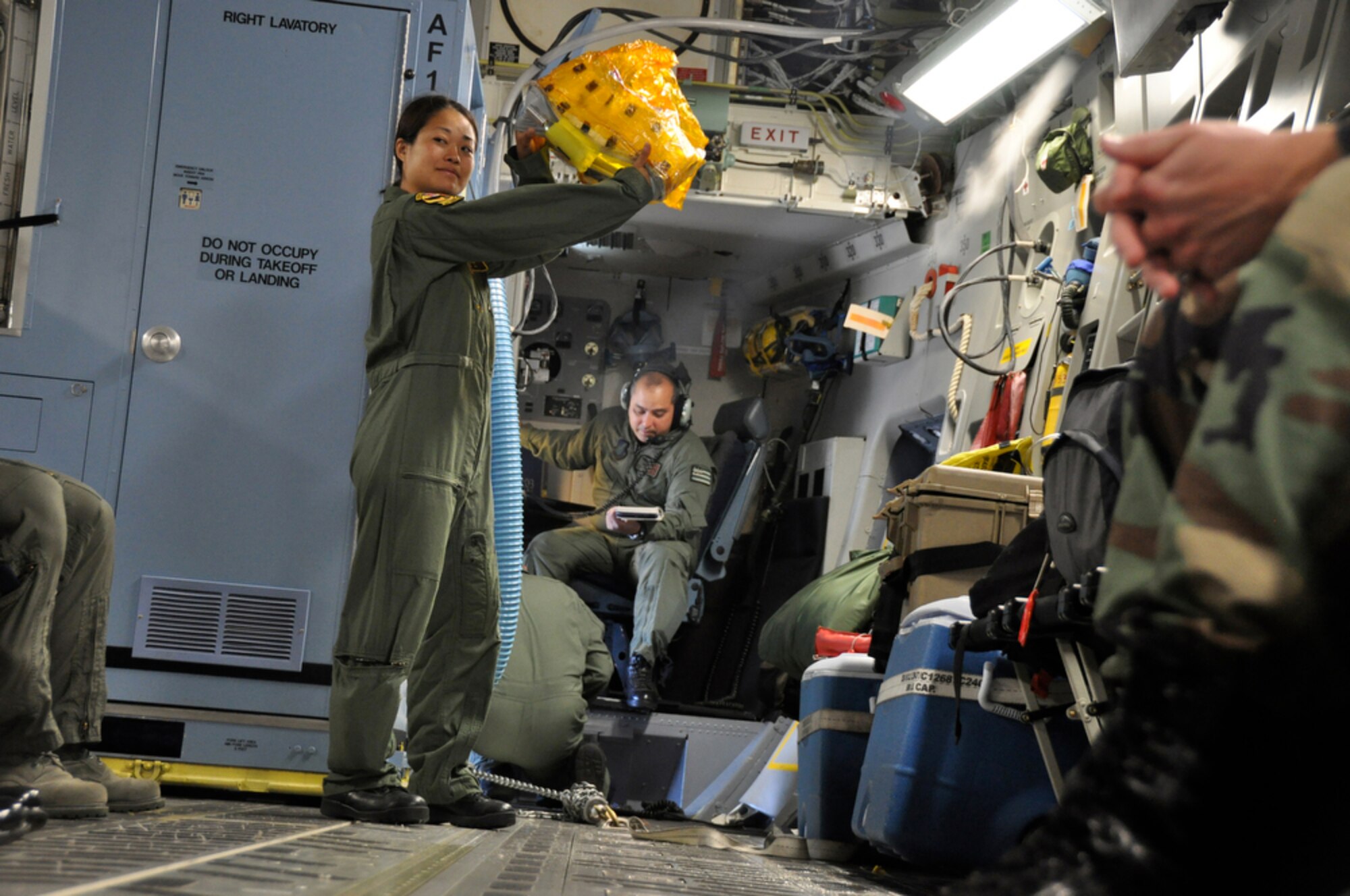 Tech. Sgt. Kimberly Kido demonstrates the proper use of the Emergency Passenger Oxygen System to passengers before departing Hickam Air Force Base, Hawaii, for Kupang, Indonesia, July 14 to support of Operation Pacific Angel 2009. Sergeant Kido is a loadmaster with the Hawaii Air National Guard?s 204th Airlift Squadron at Hickam. Pacific Angel is a Pacific Air Forces humanitarian assistance operation in the Asia-Pacific region led by 13th Air Force at Hickam AFB. (U.S. Air Force photo/Tech. Sgt. Cohen A. Young)