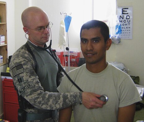 Capt. Mike McCarter, physician?s assistant for the Provincial Reconstruction Team in Zabul Province, Afghanistan, examines Staff Sgt. Paul Herrera July 16. Provincial Reconstruction Teams have been operating in Afghanistan since 2002, and work with provincial government and the local populace to improve security, development and governance. (DoD Photo by U.S. Air Force Maj. J.D. Loftis)