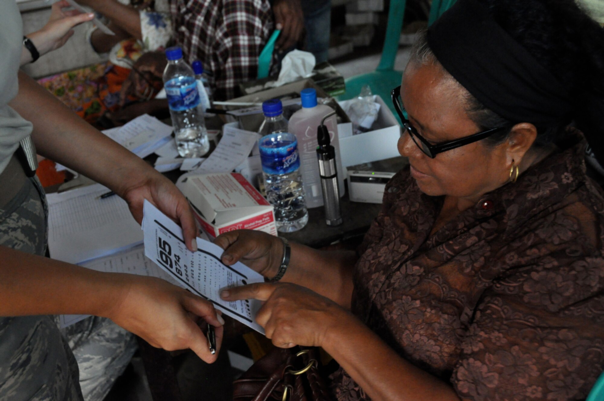 An East Timorese woman verifies her vision has improved thanks to a new pair of glasses after being seen by U.S. Air Force eye specialists at a clinic in Dili, Timor Leste, July 20.  The clinic was set up as part of Operation Pacific Angel 2009, a Pacific Air Forces humanitarian assistance operation in the Asia-Pacific region led by 13th Air Force at Hickam Air Force Base, Hawaii. (U.S.  Air Force photo/Tech. Sgt. Cohen A. Young)